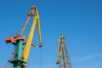 Fototapeta na wymiar Two port cranes over blue sky background.