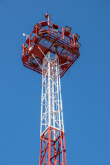 Security tower with spotlight over blue sky background.