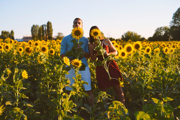 Obraz na płótnie Canvas couple hides behind sunflower