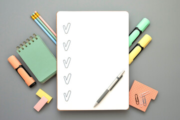 Blank checklist with paper clip checkmarks, pen on white sheet. Stylish office, educational stationery around. Checklist for office worker, student, manager, businessman. Grey background. Copy space.
