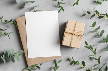Greeting card mockup with gift, envelope and green eucalyptus twigs