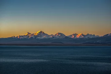 Foto op Plexiglas Shishapangma Beautiful shot of the Pekucuo lake and Shishapangma snowy mountains during sunrise in Xigaze, China