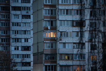 Light in one window in apartment multistorey building during the rolling blackout of electricity in...
