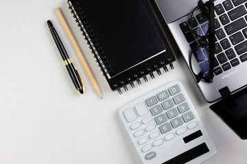 top view of modern white office desk with computer keyboard, blank notebook page and other equipment on white background. Workspace concept, workspace management style, business design space with copy