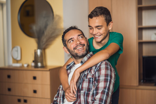 Portrait of happy father and son at home. They are embracing.