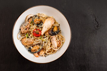 Tasty pasta with a seafood and vegetables on wooden background