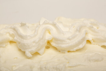 Cake cream texture, sweet whipped cream. Background of yogurt close-up with a pattern.