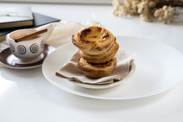 Pasteis de nata, traditional sweet of Portuguese cuisine. Small crunchy puff pastry pies and a cream made with eggs. Often tasted and accompanied with coffee. On white background and copy space.
