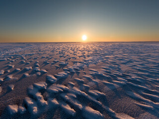 The surface of a frozen lake. Sunset in winter.