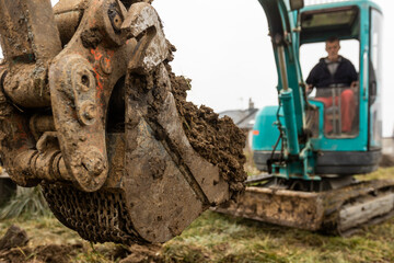 Fototapeta premium Close up of excavator or digger digging some soil or clay, industrial concept