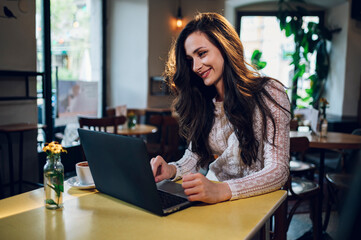 Portrait of beautiful young woman using laptop in a cafe