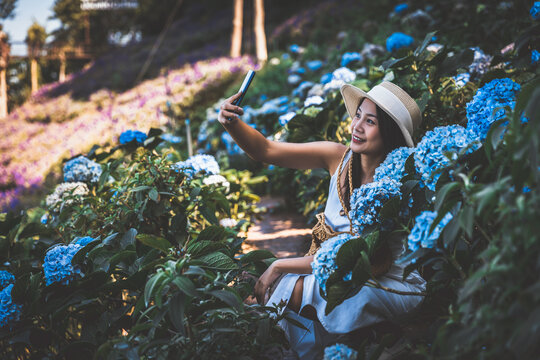 Traveler woman with mobile phone travel in flower garden at Chiang Mai Thailand
