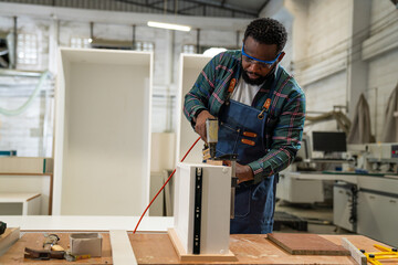 Afro american craftsman working as carpenter in a carpentry workshop, Small family business concept of young entrepreneurs.