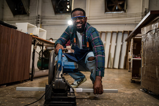 Afro American Craftsman Working As Carpenter In A Carpentry Workshop, Small Family Business Concept Of Young Entrepreneurs.