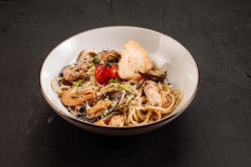 Tasty pasta with a seafood and vegetables on wooden background