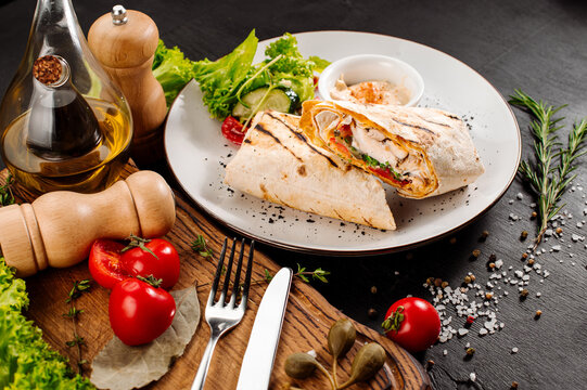 Tasty dish of pita with meat and vegetables on wooden background