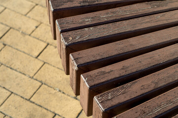 Close-up of part of the seat of a bench made of wooden bars assembled with a lattice. Unusual...