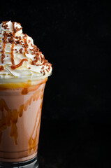 Chocolate milkshake in a plastic cup. on a black background. Free space for text.