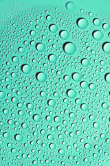 Detail close up of condensation drops of water on teal surface. Texture background decoration.
