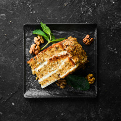 Delicious nut cake on a black stone plate. Top view. Rustic style.