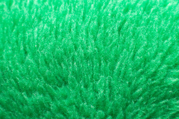 Green fluffy textile texture. Nappy hairy background closeup.