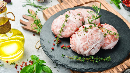 Caul-Fat Meatballs raw burger cutlet handmade. On a stone board. On a black background. Top view.
