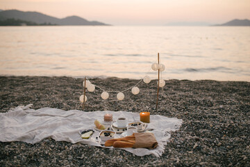 Romantic picnic by the sea at sunset.