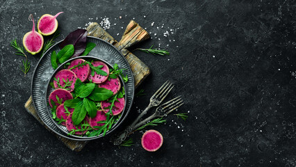 Fresh healthy salad: spinach, radish watermelon, black sesame and olive oil. Healthy food. Top view. On a stone background.