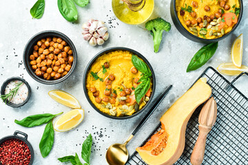 Hummus from chickpeas and pumpkin and carrots, with olive oil and spices. Healthy vegetarian food. On a concrete background.