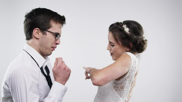 Comic, energy and dance of couple at wedding with goofy, silly and groovy peace hand with smile. Wellness, bride and groom celebrate happy marriage with funny party dancing in white studio.