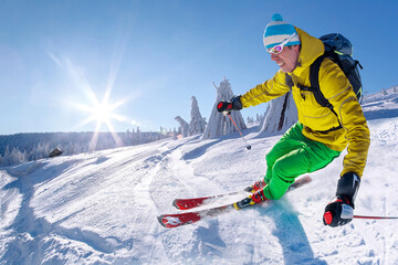 Fototapeta na wymiar Skier skiing downhill in high mountains against blue sky.