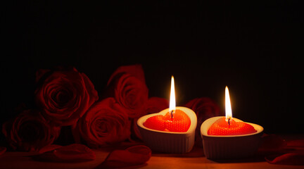 red roses with burning candles on dark background