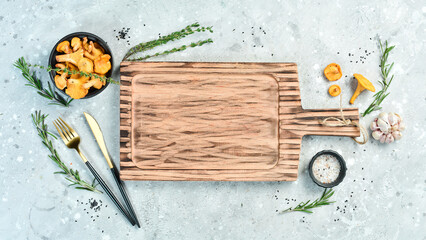 Cooking concept. Wooden kitchen board on a gray stone background. Top view. Free space for your text.