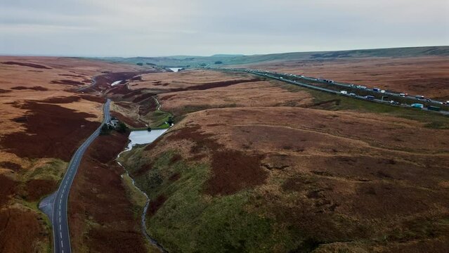 Aerial  timelapse hyper lapse motion lapse footage of the M62 motorway at Saddleworth Moor in the United Kingdom. Showing Mooreland, lake, reservoir, traffic and motion.