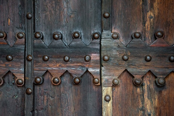 Fototapeta na wymiar Detail of the wooden door of the Shrine Of the Beato Sante near Monbaroccio, a little fortified village in the Province of Pesaro e Urbino in the Italian region Marche