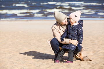 Woman with her three old daughter walking on sandy beach