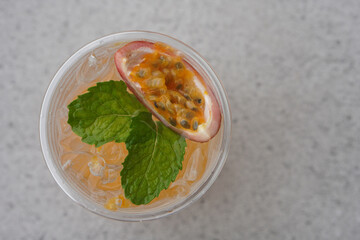 top view fresh passion fruit soda in plastic glass on blur grey marble floor background, fruit, drink, food, copy space