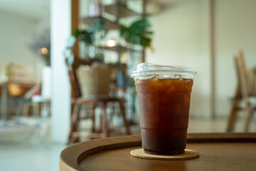 Close-up of Americano ice coffee or black coffee in cup mug on  wood desk office desk in coffee shop at the cafe in garden,during business work concept