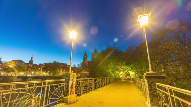 Hyperlapse sunset of Isar river and St. Lukas Church, Munich, Germany sunset day to night 4K