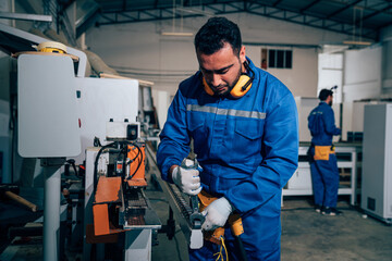 Male technician worker checking and repair pressing metal machine at factory, Machine maintenance technician operation concept.