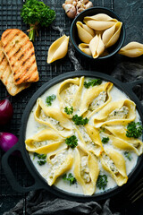 Pasta stuffed with turkey meat, cream sauce and parmesan. In a frying pan. Italian traditional cuisine. Recipe.