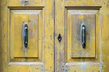 A yellow wooden door in Monbaroccio a little fortified village in the Province of Pesaro e Urbino in the Italian region Marche