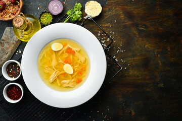 Quail soup. Quail meat broth with quail eggs and noodles. In a white plate. Top view.