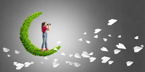 Concept of careless happy childhood with girl on green moon