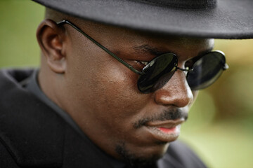 Fototapeta premium Close up of African American man wearing black hat with sunglasses