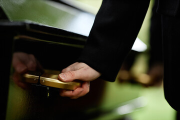 Close up of hand on coffins handle at outdoor funeral ceremony, copy space - obrazy, fototapety, plakaty