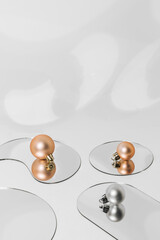 Abstract Christmas and New Year background with golden and silver baubles lying on reflective mirrors