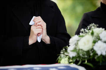 Close up of woman holding handkerchief and crying at outdoor funeral ceremony, copy space