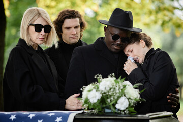 Portrait of woman crying at outdoor funeral ceremony and wearing black, copy space