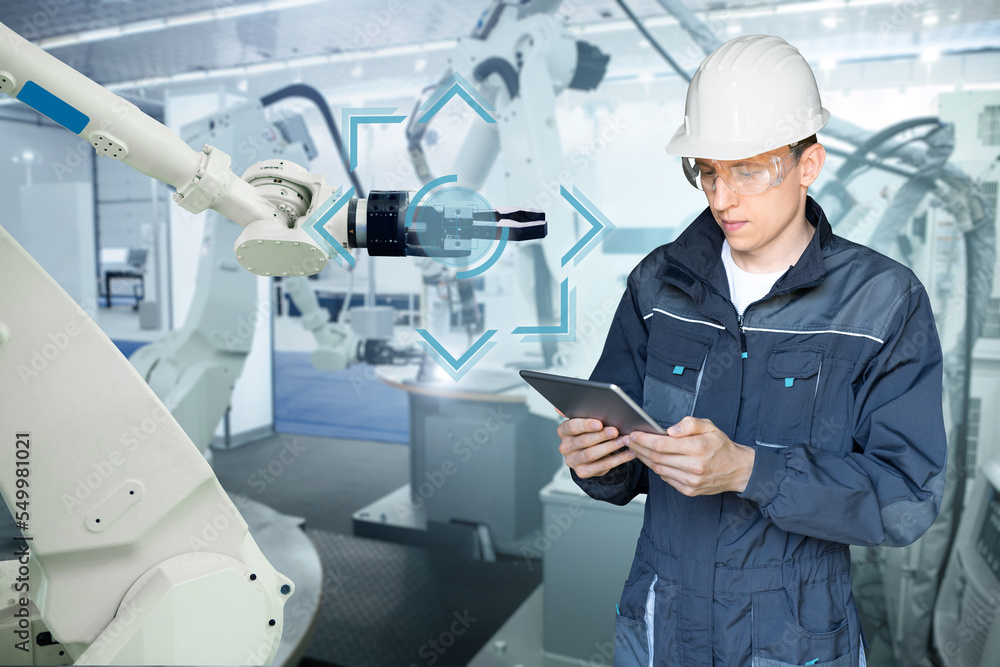 Fototapete Engineer uses a digital tablet to control robots in a smart factory. Smart industry 4.0 concept